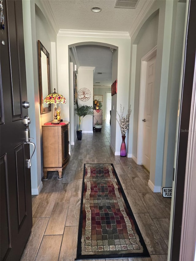 1231 Merion Dr, Mount Dora, FL 32757 - hallway featuring wood finished floors, crown molding, baseboards, and arched walkways