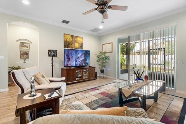1231 Merion Dr, Mount Dora, FL 32757 - living room featuring ceiling fan, baseboards, crown molding, light wood finished floors, and recessed lighting