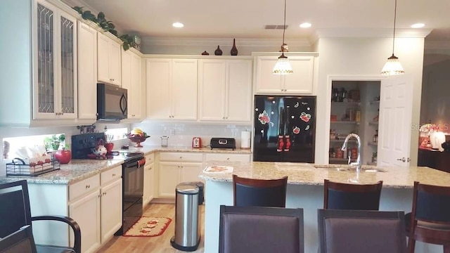 1231 Merion Dr, Mount Dora, FL 32757 - kitchen with black appliances, a sink, a breakfast bar area, glass insert cabinets, and hanging light fixtures