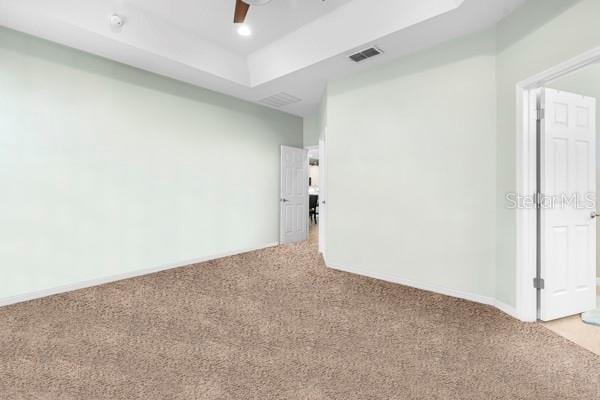 1231 Merion Dr, Mount Dora, FL 32757 - empty room with light colored carpet, a raised ceiling, and ceiling fan