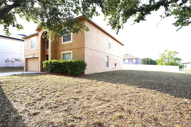 3329 White Blossom Ln, Clermont, FL 34711 - view of side of home with an attached garage, stucco siding, and driveway