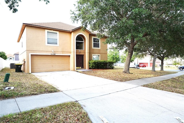 3329 White Blossom Ln, Clermont, FL 34711 - view of front facade featuring an attached garage, stucco siding, concrete driveway, and central AC unit