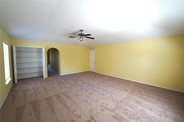 3329 White Blossom Ln, Clermont, FL 34711 - carpeted empty room featuring a ceiling fan, arched walkways, plenty of natural light, and baseboards