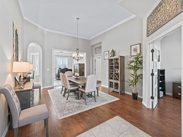 17471 SE 110th Ter, Summerfield, FL 34491 - dining space with a chandelier, arched walkways, crown molding, baseboards, and dark wood-type flooring