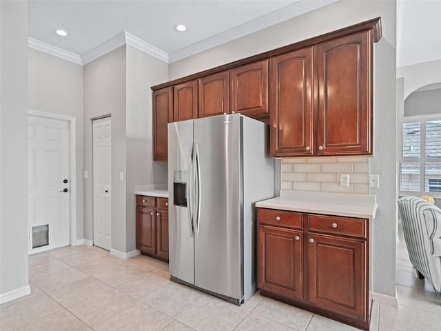 17471 SE 110th Ter, Summerfield, FL 34491 - kitchen with stainless steel fridge, arched walkways, light countertops, ornamental molding, and light tile patterned flooring