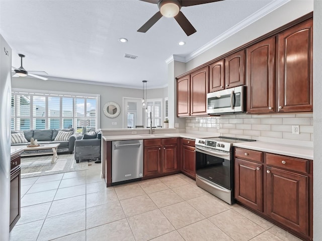 17471 SE 110th Ter, Summerfield, FL 34491 - kitchen featuring appliances with stainless steel finishes, ceiling fan, crown molding, light countertops, and a peninsula