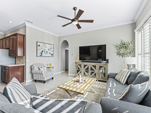17471 SE 110th Ter, Summerfield, FL 34491 - living room with arched walkways, crown molding, ceiling fan, baseboards, and light tile patterned floors