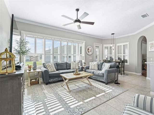 17471 SE 110th Ter, Summerfield, FL 34491 - living room with arched walkways, ceiling fan, light tile patterned floors, crown molding, and baseboards