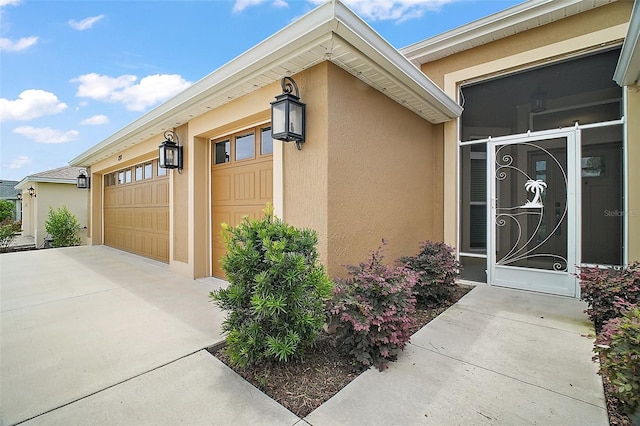 892 Hubbard Loop, The Villages, FL 32163 - doorway to property with stucco siding, driveway, and an attached garage
