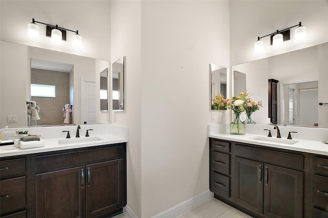 892 Hubbard Loop, The Villages, FL 32163 - bathroom featuring two vanities, a towering ceiling, baseboards, and tile patterned floors