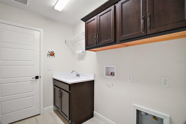 892 Hubbard Loop, The Villages, FL 32163 - washroom featuring cabinet space, washer hookup, baseboards, light tile patterned floors, and a textured ceiling