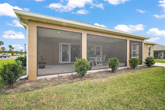 892 Hubbard Loop, The Villages, FL 32163 - back of property with a yard, a sunroom, and stucco siding
