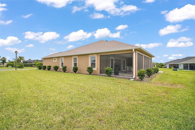 892 Hubbard Loop, The Villages, FL 32163 - back of house featuring a lawn, a sunroom, and stucco siding