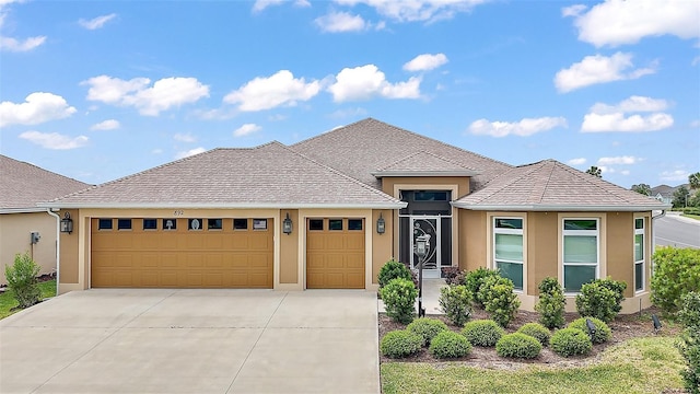 892 Hubbard Loop, The Villages, FL 32163 - view of front of home with stucco siding, an attached garage, and concrete driveway