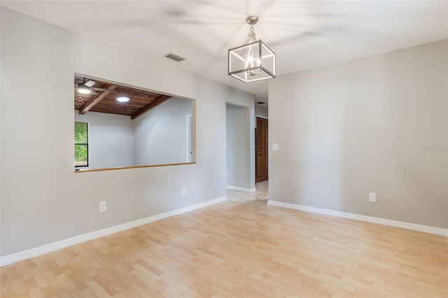 8410 Lake Bosse Dr, Orlando, FL 32810 - unfurnished room with wood finished floors, a chandelier, baseboards, and beam ceiling