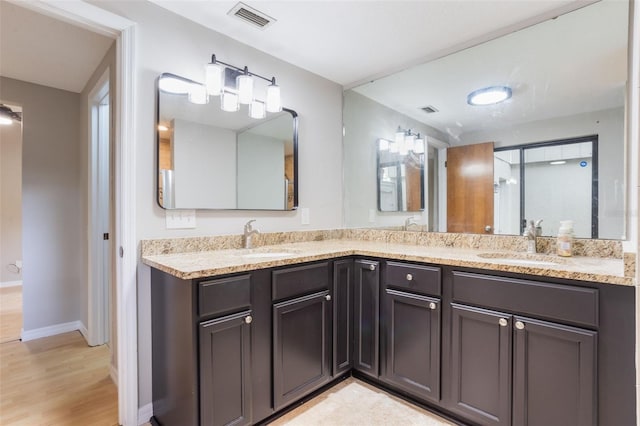 8410 Lake Bosse Dr, Orlando, FL 32810 - bathroom with double vanity, wood finished floors, and baseboards