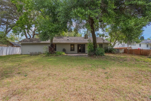 8410 Lake Bosse Dr, Orlando, FL 32810 - back of house featuring stucco siding and a chimney