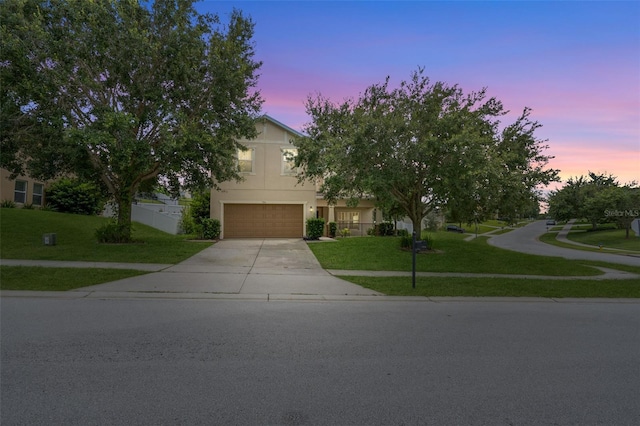 356 Giovani Blvd, Clermont, FL 34715 - view of property hidden behind natural elements featuring driveway, a front lawn, a garage, and stucco siding