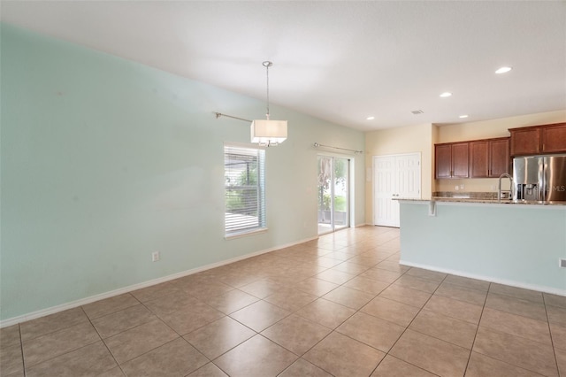 356 Giovani Blvd, Clermont, FL 34715 - kitchen with stainless steel refrigerator with ice dispenser, light tile patterned flooring, recessed lighting, light countertops, and a breakfast bar area