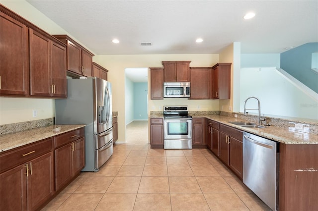 356 Giovani Blvd, Clermont, FL 34715 - kitchen with appliances with stainless steel finishes, light stone counters, recessed lighting, a peninsula, and light tile patterned floors