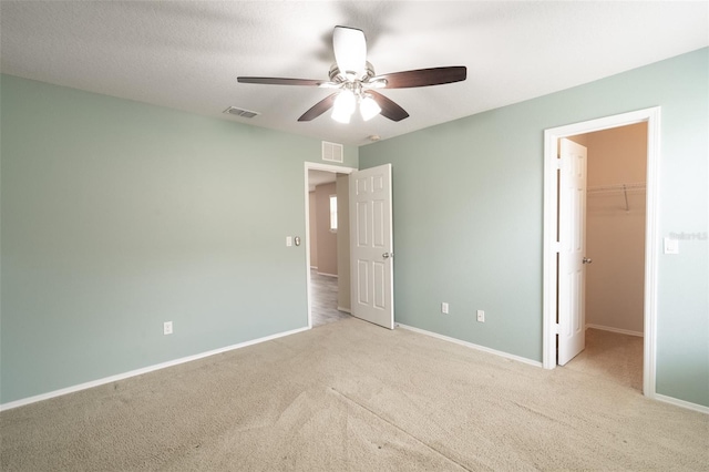 356 Giovani Blvd, Clermont, FL 34715 - unfurnished bedroom with a spacious closet, carpet, and a ceiling fan