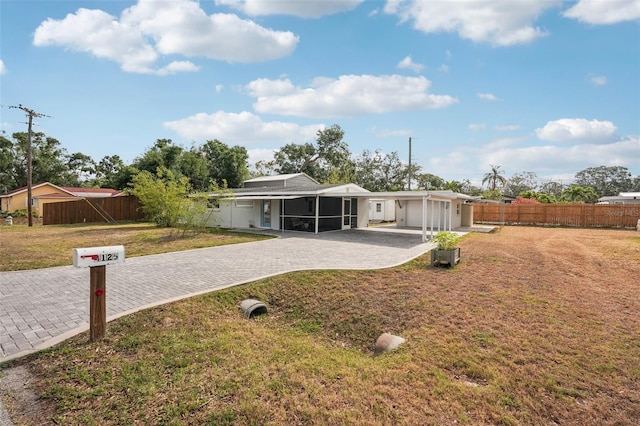 4125 Worcester Rd, Sarasota, FL 34231 - view of front of home with a sunroom and decorative driveway