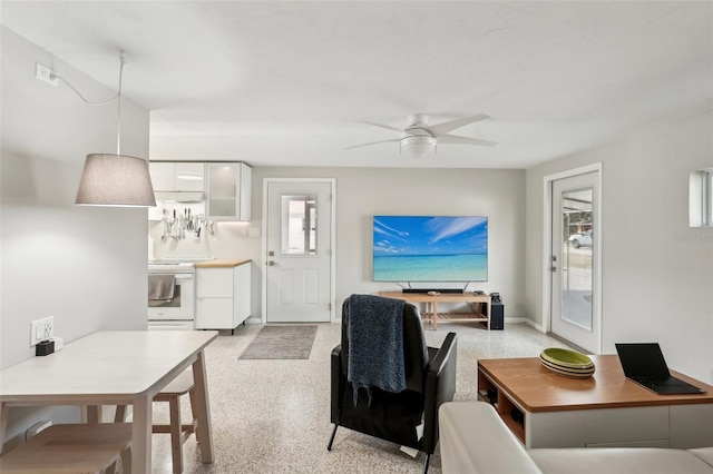 4125 Worcester Rd, Sarasota, FL 34231 - living area featuring dark aggregate flooring, a ceiling fan, and baseboards