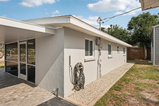 4125 Worcester Rd, Sarasota, FL 34231 - view of side of property with fence, stucco siding, and a patio area