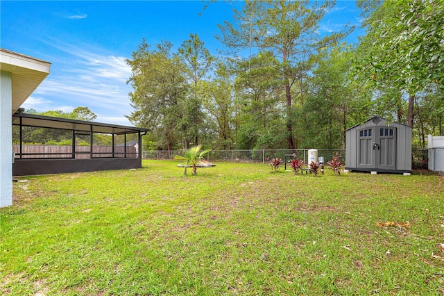 view of yard with a shed, a sunroom, and an outdoor structure