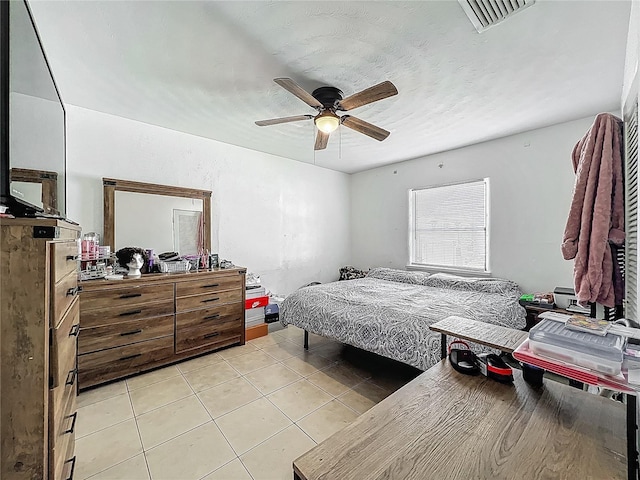 bedroom with ceiling fan, light tile patterned floors, and visible vents