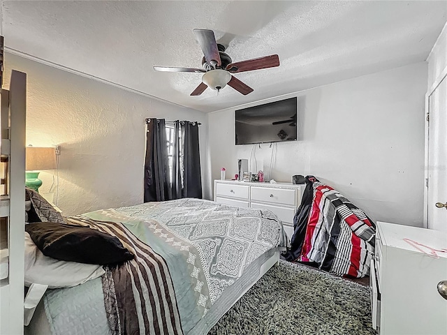 carpeted bedroom with ceiling fan and a textured ceiling