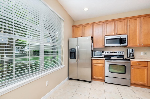 866 Ashworth Overlook Dr Unit B, Apopka, FL 32712 - kitchen with appliances with stainless steel finishes, light tile patterned floors, light countertops, brown cabinetry, and recessed lighting