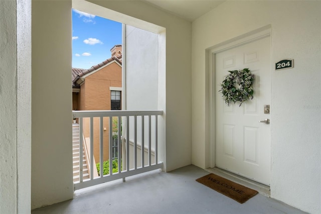 doorway to property featuring stucco siding and a balcony
