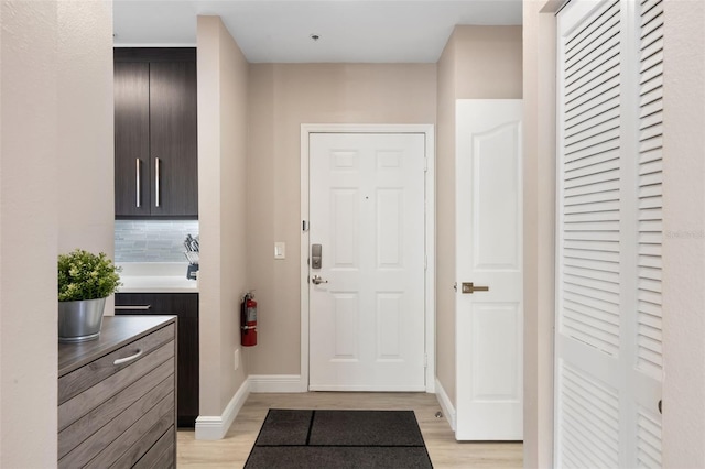 entryway with baseboards and light wood-style floors
