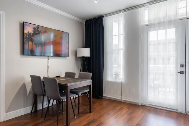 dining room with baseboards, ornamental molding, and wood finished floors