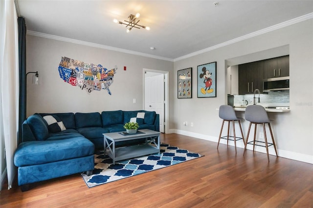 living room with baseboards, crown molding, and wood finished floors