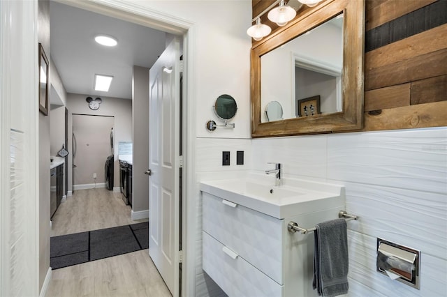 bathroom with baseboards, wood finished floors, and vanity