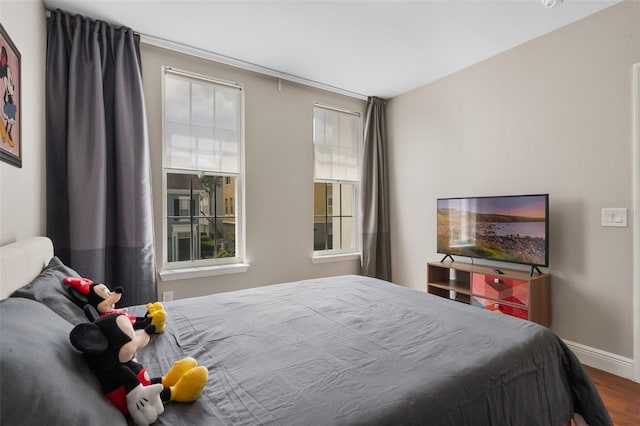 bedroom with baseboards and wood finished floors