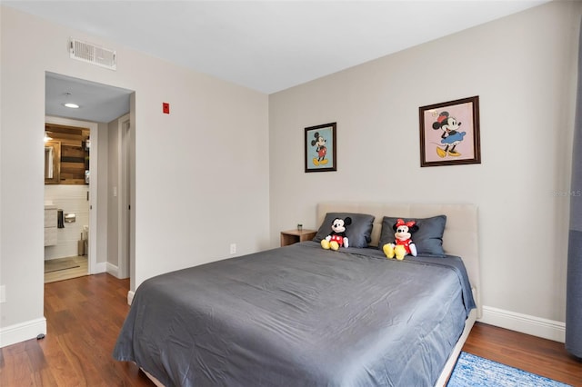 bedroom featuring wood finished floors, visible vents, and baseboards