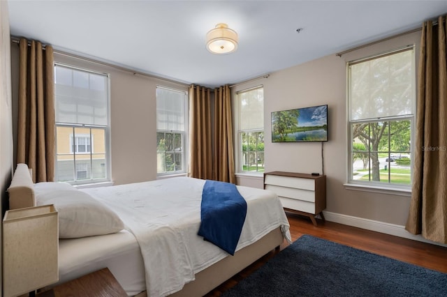 bedroom with baseboards and wood finished floors