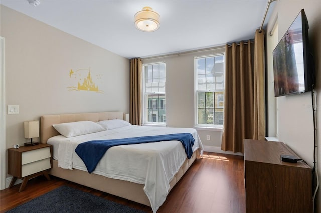 bedroom featuring baseboards and dark wood finished floors