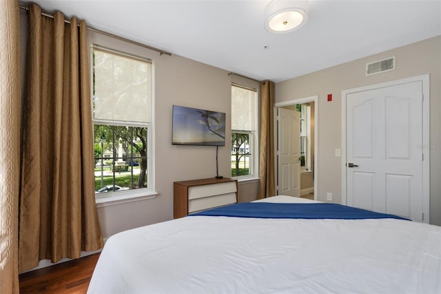 bedroom with visible vents and dark wood finished floors