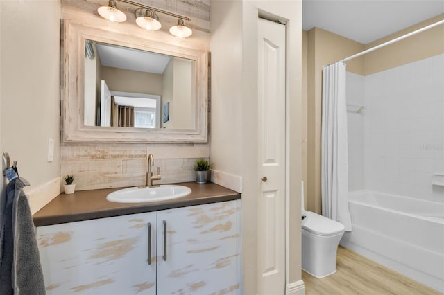 bathroom featuring toilet, tasteful backsplash, wood finished floors, vanity, and shower / bathtub combination with curtain