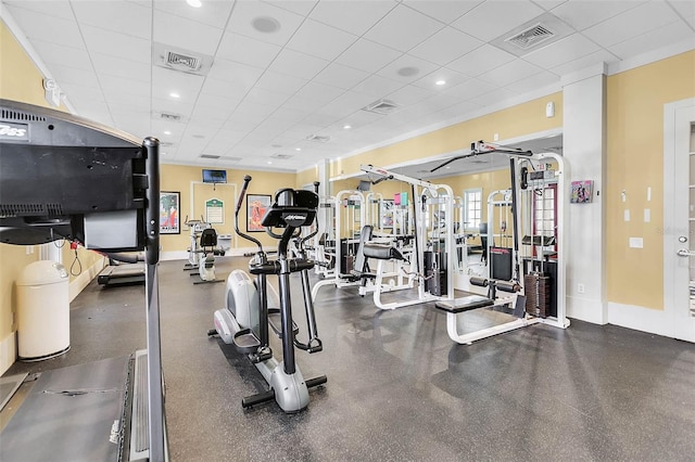 gym featuring a paneled ceiling, baseboards, and visible vents