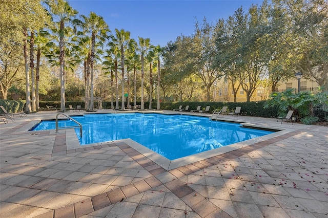 pool with a patio area and fence