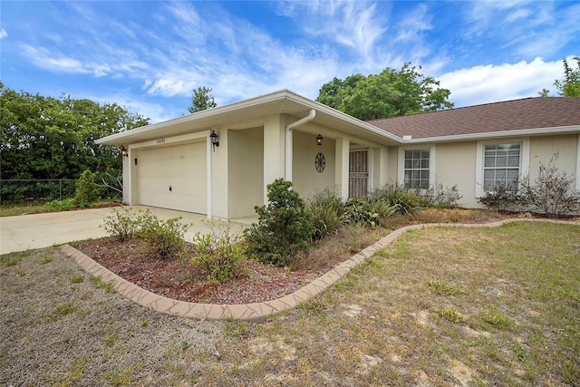 ranch-style home featuring stucco siding, driveway, an attached garage, and fence