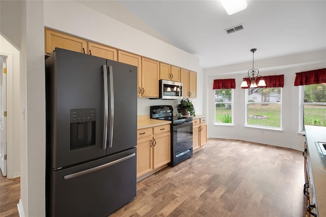kitchen with fridge with ice dispenser, electric range, stainless steel microwave, light brown cabinetry, and vaulted ceiling