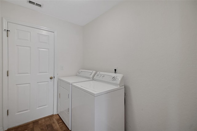 clothes washing area featuring washer and clothes dryer and dark wood-style flooring