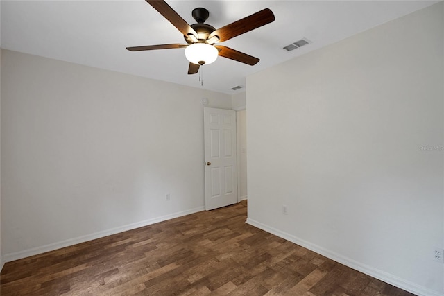 spare room with wood finished floors, a ceiling fan, and baseboards