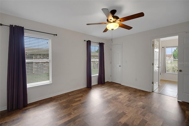 unfurnished room with a ceiling fan, wood finished floors, and baseboards